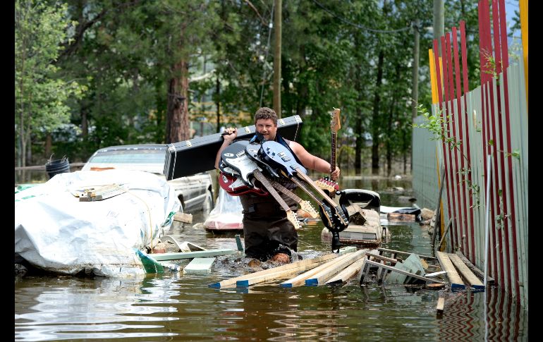 Un vecino carga las guitarras de un amigo entre una inundación en Grand Forks, Canadá. Las temperaturas cálidas de esta semana han provocado el derretimiento de nieve y la consiguiente crecida de ríos en la región de Columbia Británica. AP/The Canadian Press/J. Hayward