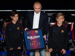 Iniesta, un símbolo del Barcelona, apareció acompañado por dos jóvenes miembros del club. AFP/J. Lago