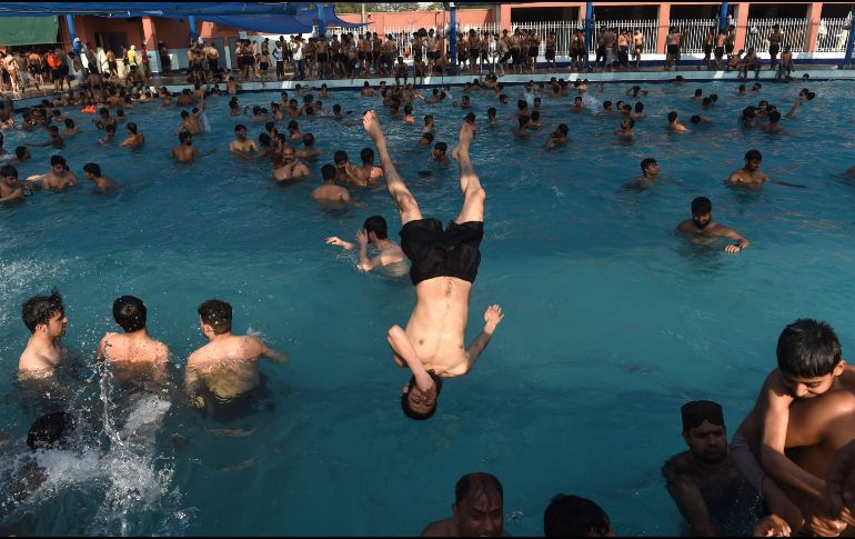 Jóvenes se refrescan en una alberca durante un día caluroso en Lahore, Pakistán. AFP/A. Ali