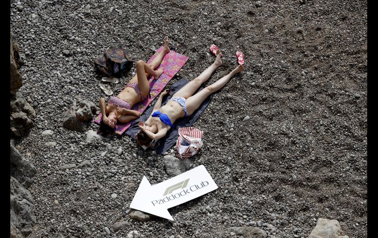 Mujeres se asolean durante la carrera del Gran Premio de la Fórmula 1 en Mónaco. AP/L. Bruno
