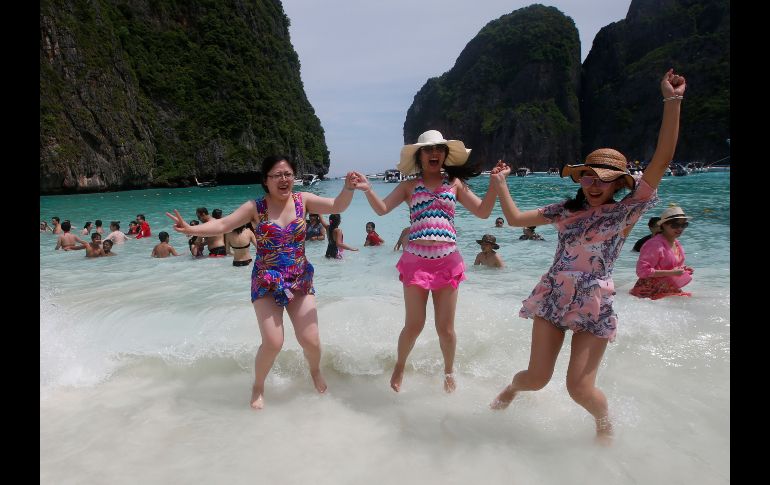 Turistas saltan en la bahía Maya, ubicada en la isla tailandesa Phi Phi Leh. La bahía cerrará a los turistas por cuatro meses a partir demañana, para dar tiempo a la recuperación de los arrecifes de coral y la vida marina de la zona. AP/S. Lalit