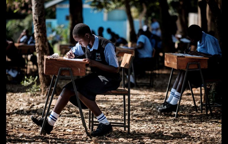 Estudiantes de una secundaria toman un examen de inglés afuera, debido a que su salón está sobre saturado, en Kisumu, Kenia. AFP/Y. Chiva