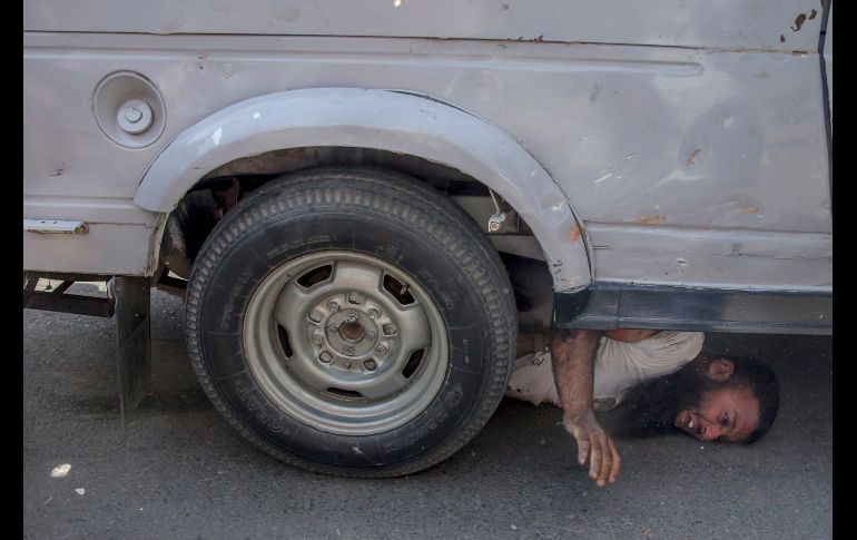 Un cachemir pide ayuda mientras un auto de paramilitares lo arrolla, durante una protesta en Srinagar, territorio de Cachemira controlado por India. Tres personas resultaron con heridas, una de ellas graves, luego de que el vehículo los atropelló. AP/D. Yasir