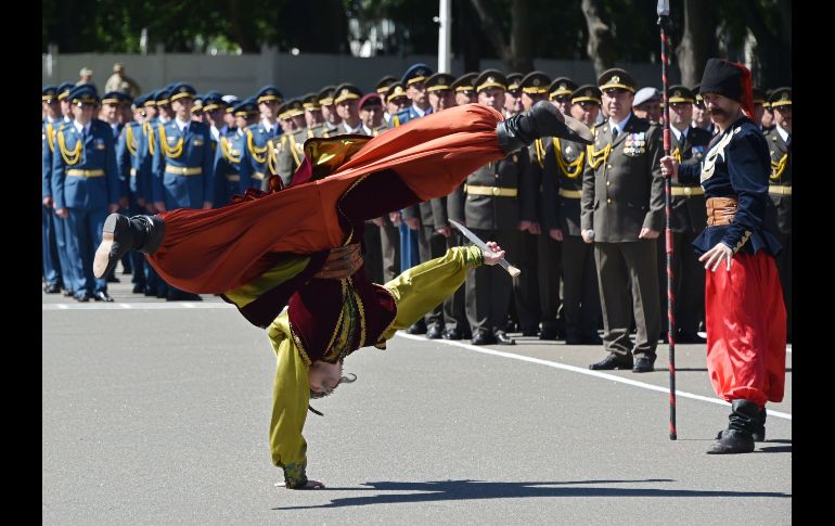 Un artista en atuendo tradicional ucraniano se presenta en una ceremonia de graduación de la Universidad Nacional Ucraniana de Defensa en Kiev. AFP/G. Savilov