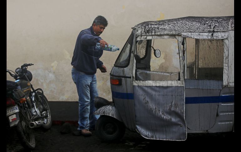 Un habitante quta ceniza de su mototaxi. EFE/E. Biba