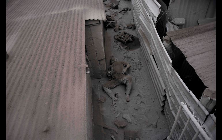 Una víctima yace entre la ceniza en una casa en San Miguel Los Lotes. El barro volcánico barrió este pueblo, justo debajo de los flancos de la montaña.
