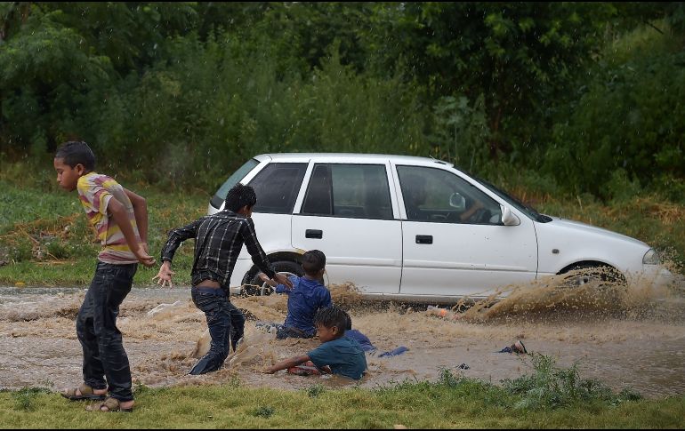Niños se refrescan en un charco de agua de lluvia, durante una ola de calor que azota Islamabad, Pakistán. AFP/A. Qureshi