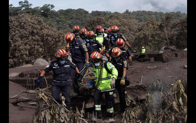 Bomberos cargan un cuerpo recuperado en San Miguel Los Lotes, Guatemala. El número de víctimas mortales por la erupción del Volcán de Fuego suma al menos 75. AFP/J. Ordonez