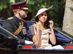 Meghan lucía un vestido con los hombros destapados de color melocotón pálido de Carolina Herrera, y sombrero de Philip Treacy, mientras que su esposo iba de uniforme. AFP/N. Hallen