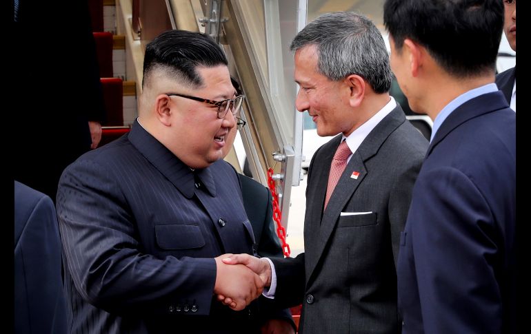 El líder norcoreano Kim Jong-Un (i) a su llegada al aeropuerto Changi en Singapur, donde fue recibido por el secretario de Exteriores Vivian Balakrishnan. Kim llegó al país para su encuentro, el 12 de junio, con el presidente de EU Donald Trump. AP/Ministerio de Comunicaciones e Información de Singapur