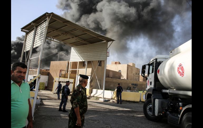 Policías se ven afuera del mayor almacén de boletas electorales de Iraq, en Bagdad, tras un incendio. El incidente se produce antes de un recuento de votos ordenado por el parlamento. AFP/S. Arar