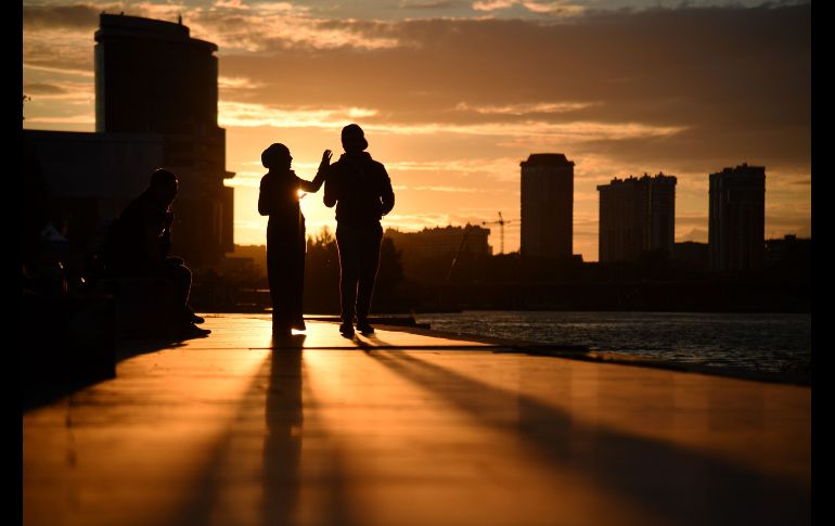Una pareja camina junto al río Iset en Ekaterinmburgo, Rusia. AFP/H. Retamal