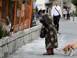Una mujer ofrece su condolencia a una víctima del terremoto, una colegiala que murió al derrumbarse una pared debido al sismo. EFE/JIJI