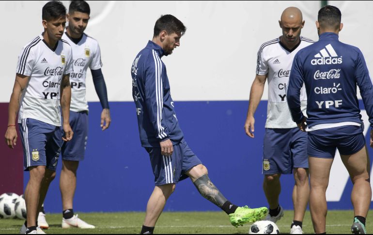 Lionel Messi (C) controla el balón mientras Javier Mascherano (2d), Maximiliano Meza (i) y Ever Banega lo observan, durante los ejercicios matinales de hoy. AFP/J. Mabromata