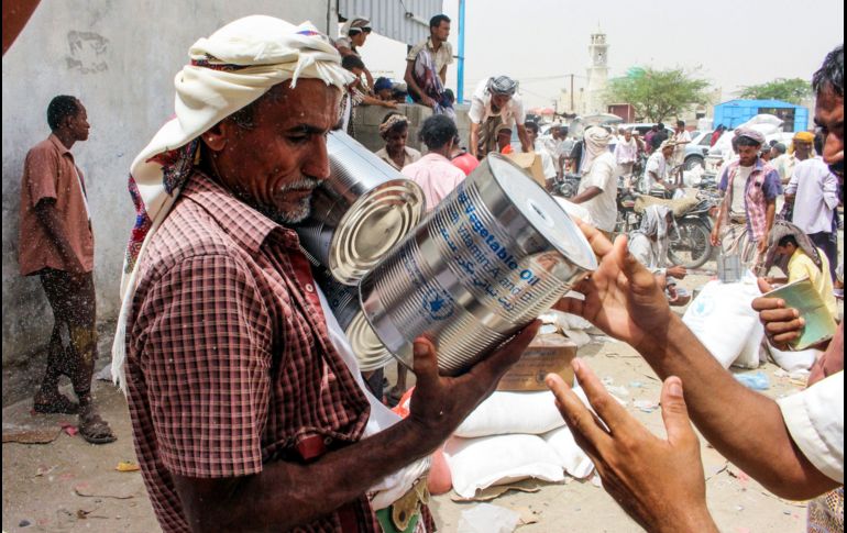 Un hombre recibe ayuda alimentaria para yemeníes desplazados por las batallas en al provicincia de Hodeida, que ahora viven en Abs, Yemen. AFP/E. Ahmed