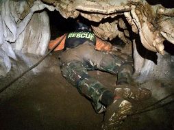 Un miembro de los equipos de rescate se arrastra para tratar de encontrar entradas alternas en la gruta, de unos 10 kilómetros de largo. AP