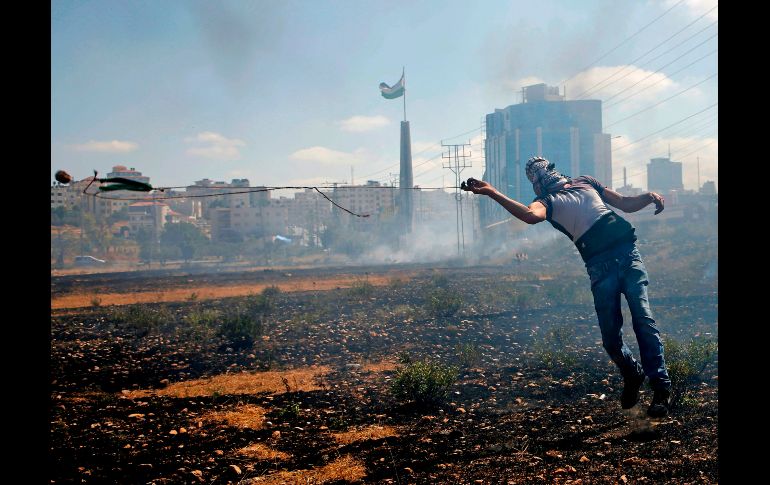 Una palestino arroja una piedra a fuerzas israelíes durante una manifestación cerca del asentamiento judío de Beit El, en la zona ocupada de Cisjordania. AFP/A. Momani
