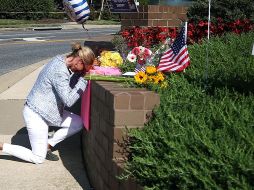 Una mujer deposita ofrendas en un memorial, carca de Capital Gazette, en Annapolis. AFP/M. Wilson