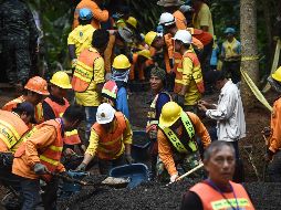 Trabajadores limpian los alrededores de la entrada a la cueva donde se asienta el campamento de rescate. AFP/L. Suwanrumpha