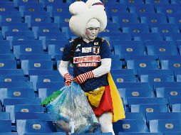 Hábito. Un japonés recoge su basura al término del partido entre Bélgica y la Selección nipona. AFP