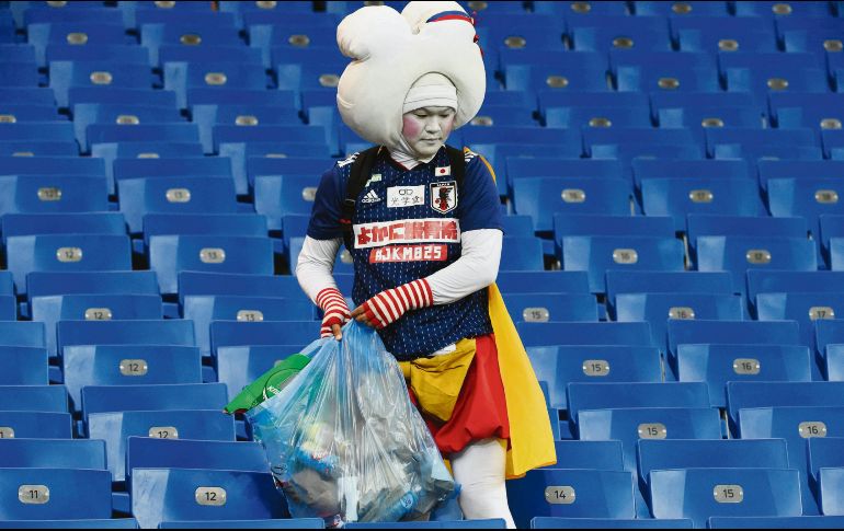 Hábito. Un japonés recoge su basura al término del partido entre Bélgica y la Selección nipona. AFP