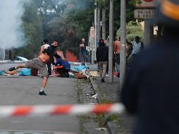 Varios manifestantes lanzan piedras a los agentes antidisturbios, quienes respondieron lanzando gases lacrimógenos. EFE/F. Dubray