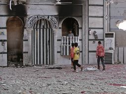 Varios ninos observan una mezquita afectada por los recientes bombardeos. AFP/Y. Karwashan