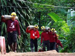Miembros de los servicios de rescate cargan con botellas de oxígeno mientras continúan las labores de rescate. EFE / R. Yongrit