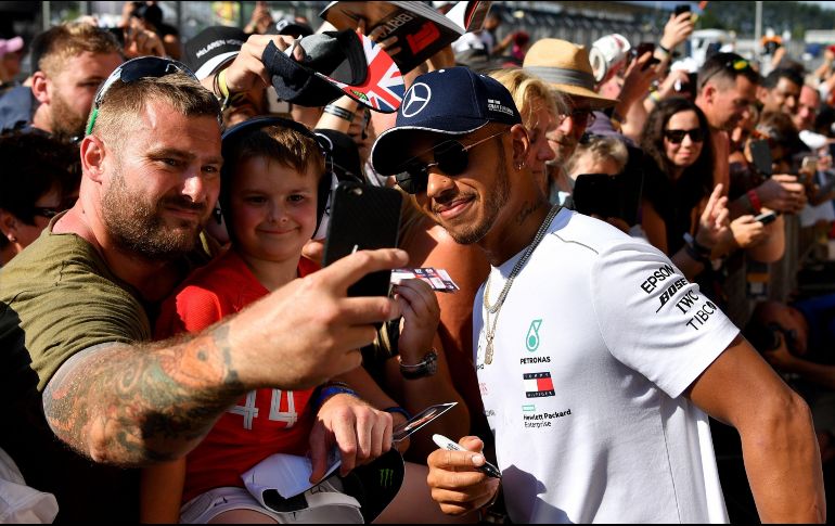El piloto de Mercedes, Lewis Hamilton, convive con aficionados en el Circuito de Silverstone, previo al inicio del GP de Gran Bretaña. AFP/A. Isakovic