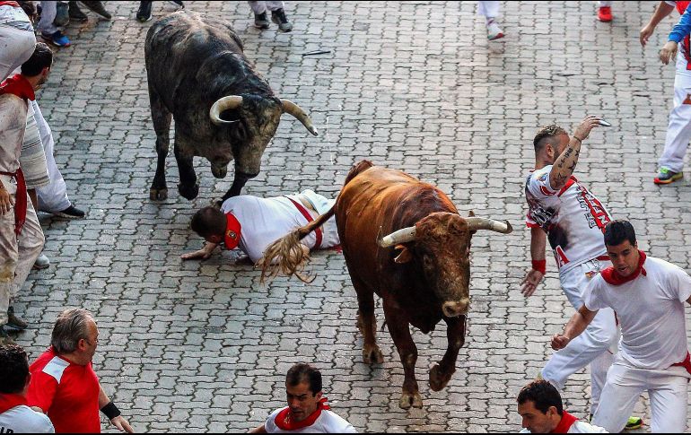 Varios mozos corren ante dos toros de la ganadería gaditana de Cebada Gago durante el tercer encierro de los Sanfermines 2018. EFE/R. Jiménez