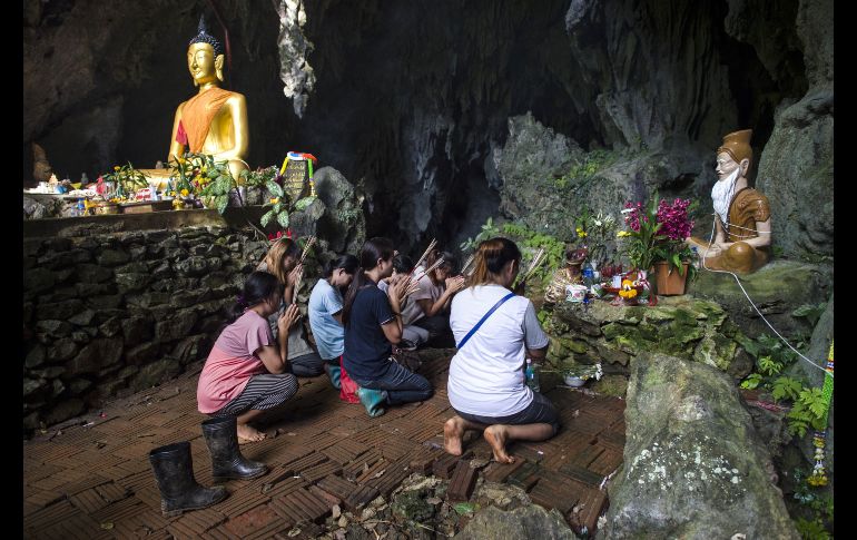 Familiares de los niños oran por ellos en un altar en las inmediaciones de la cueva, el 5 de julio. AFP/ARCHIVO