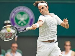 Roger Federer. El suizo regresa una bola al francés Adrian Mannarino, a quien superó en tres sets para acceder a los Cuartos de Final del torneo londinense. AFP