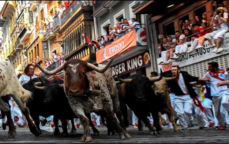 A gran velocidad y compactos, los animales hicieron el recorrido de algo más de ochocientos metros hasta la plaza de toros. AFP/J. Jordán