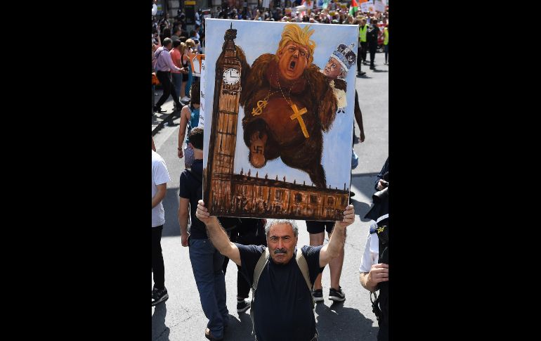 l artista satírico Kaya Mar muestra un cuadro protagonizado por el presidente de los Estados Unidos y la reina Isabel II.