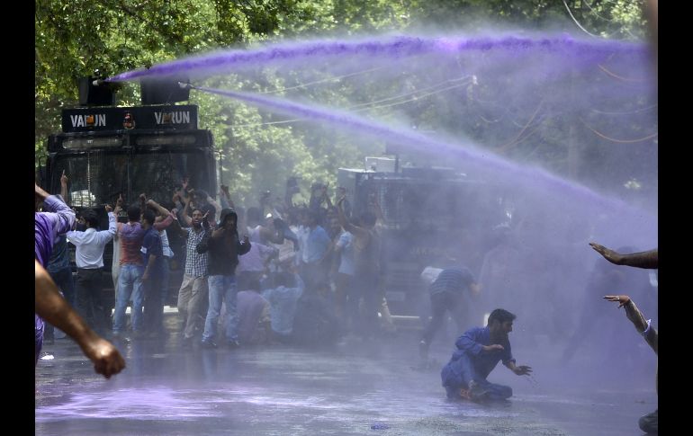 Policías arrojan agua a maestros cachemires que gritan consignas contra el gobierno en Srinagar, India. Los trabajadores demandaban incrementos salariales y la regularización de sus empleos. AFP/T. Mustafa