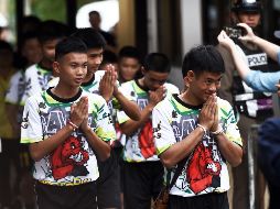 Los menores y su entrenador Ekkapol Chantawong (i) a su llegada a la rueda de prensa.AFP/L. Suwanrumpha