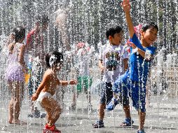 Varios niños juegan en los chorros de agua de una fuente en un parque cerca de Nerima, en Tokio. EFE/K. Mayama