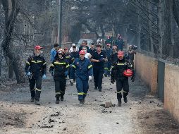 Bomberos permanecen en la zona afectada por los incendios en Argyra Akti. EFE/P. Saitas