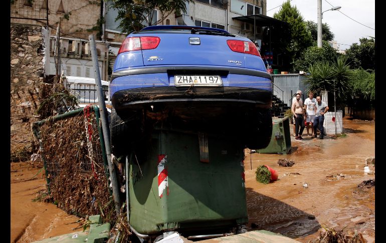 Un vehículo arrastrado por el agua quedó sobre un contenedor.