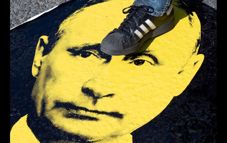Un manifestante pisa un retrato del presidente ruso Vladimir Putin, durante una protesta en contra de los planes del gobierno de aumentar la edad en que los trabajadores pueden comenzar a recibir sus pensiones. AP/P. Golovkin