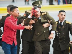 Emergencia. Varios elementos auxilian a uno de los uniformados heridos durante la crisis por una explosión en Caracas, durante un discurso del mandatario. En total se reportaron siete lesionados. AFP