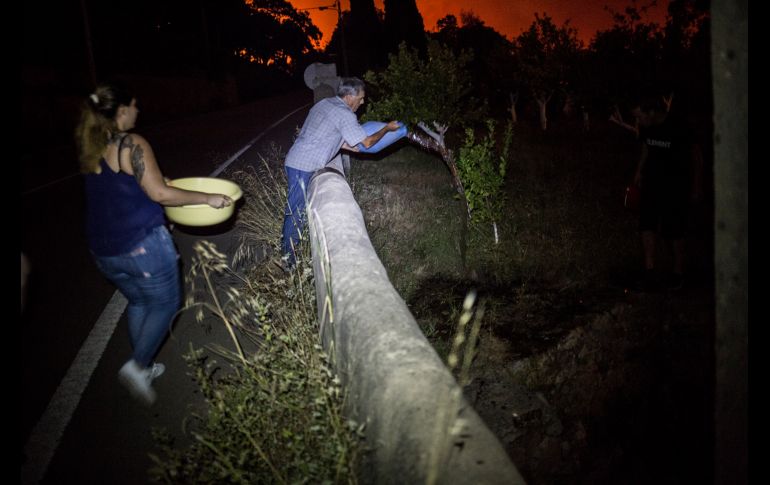 Personas arrojan agua sobre un pequeño incendio eléctrico.