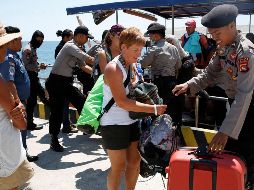 Turistas caminan con sus pertenencias tras desembarcar de un barco tras el terremoto que sacudió el norte de la isla de Lombok. EFE/A. Weda
