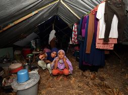 Sobrevivientes del sismo posan dentro de una de las improvisadas tiendas de campaña que les sirven como hogar. AFP/A. Berry