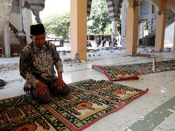 Un hombre reza en una mezquita destruida tras el terremoto. EFE/A. Weda