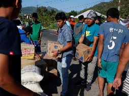 Residentes cargan con cajas de agua para su distribución entre los afectados del terremoto que el domingo sacudió el norte de la isla de Lombok. EFE/A. Weda