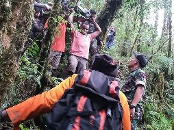 Equipos de rescate trasladan a una ambulancia al único superviviente del percance, quien presentaba una fractura en la mano. AFP/CORTESÍA