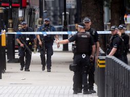 Miembros de la Policía patrullan en el lugar en el que un automóvil chocó contra las barreras del Parlamento británico en Londres. EFE/W. Oliver