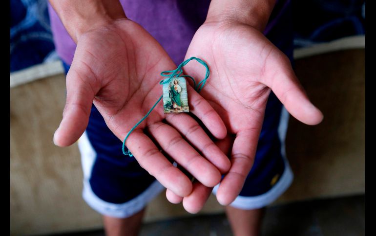 Juan Israel Rodríguez Tejeda, de 27, muestra una imagen de San Juditas, su posesión más valiosa, en un refugio en Guadalajara. AFP/U. Ruiz