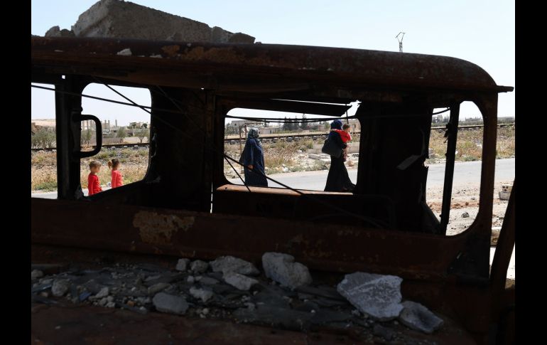 Civiles sirios entran al cruce Abu Duhur, desde la provincia Idlib. Civiles salen de áreas controladas por los rebeldes para volver a zonas retomadas por el régimen sirio. AFP/G. Ourfalian